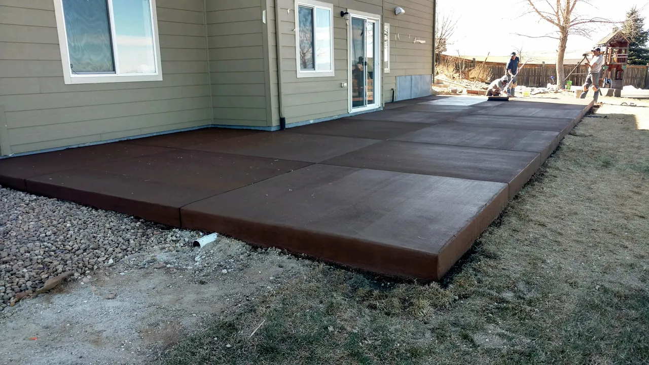 Brown colored patio along the back of a house