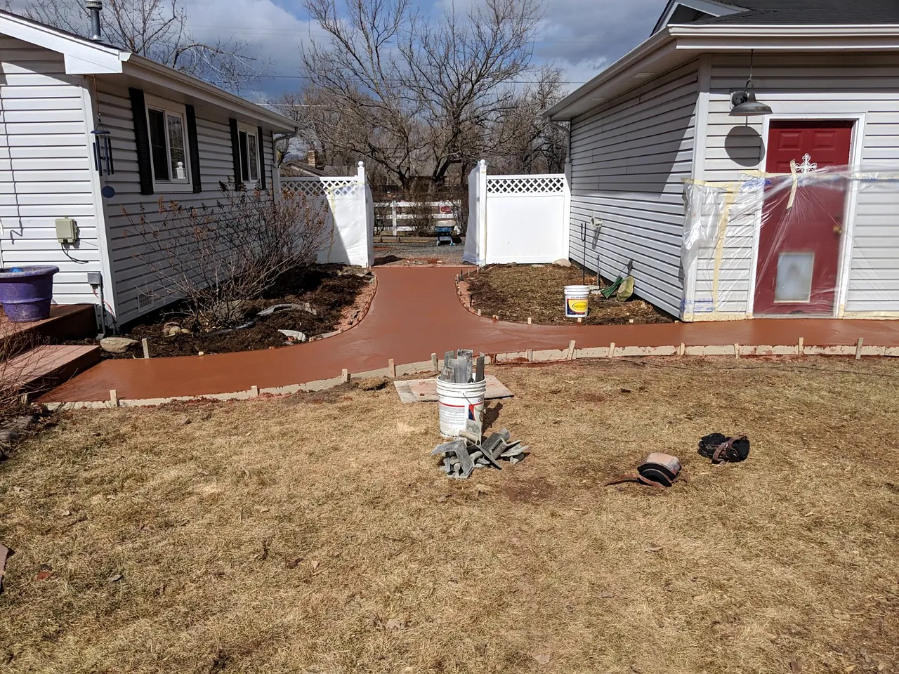 Colored concrete walkway wrapping around a home