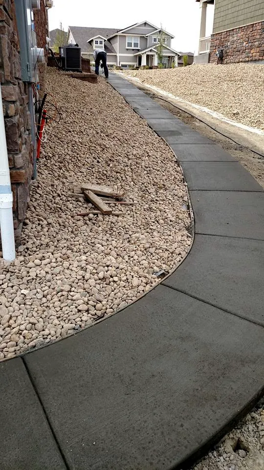 Curved sidewalk through river rock landscaping