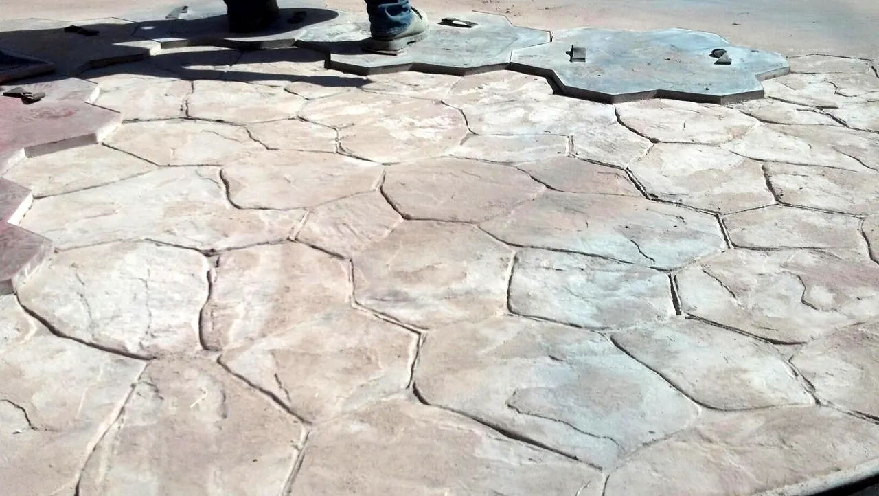 Flagstone texture mats set into fresh concrete during stamping