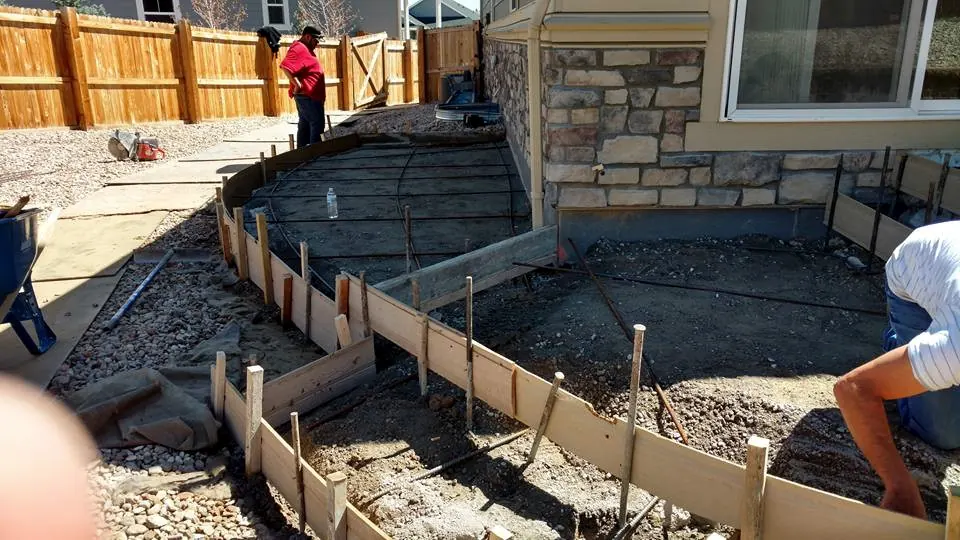 Forming a curved patio beside a stone wall