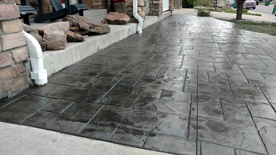 Sealed stamped front walk along a stone-faced home