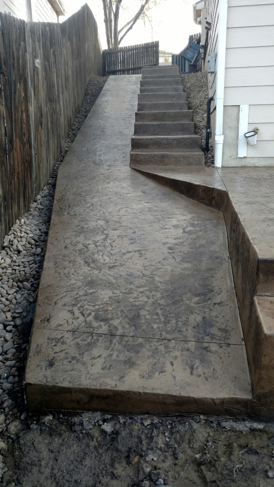 Stamped ramp walkway along a fence