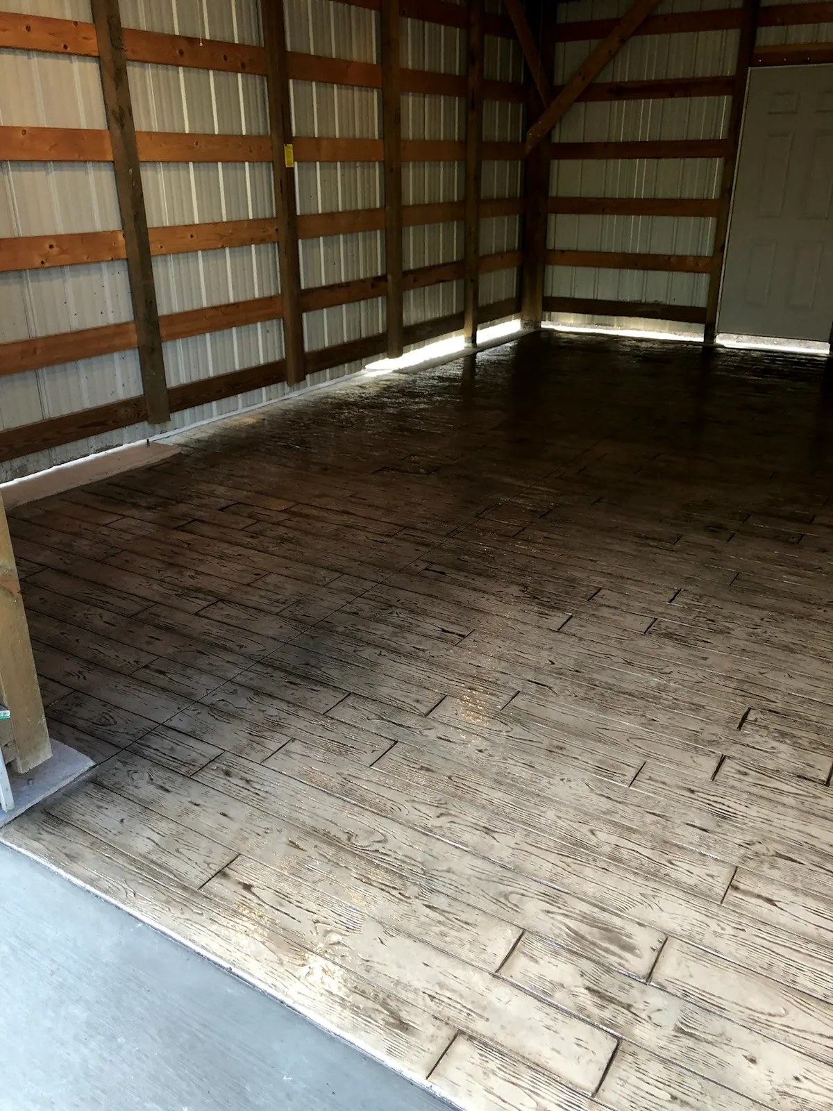 Wood-plank stamped floor inside a pole barn