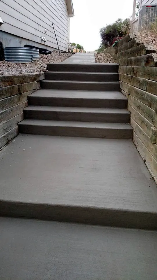 Concrete steps and landing beside a retaining wall